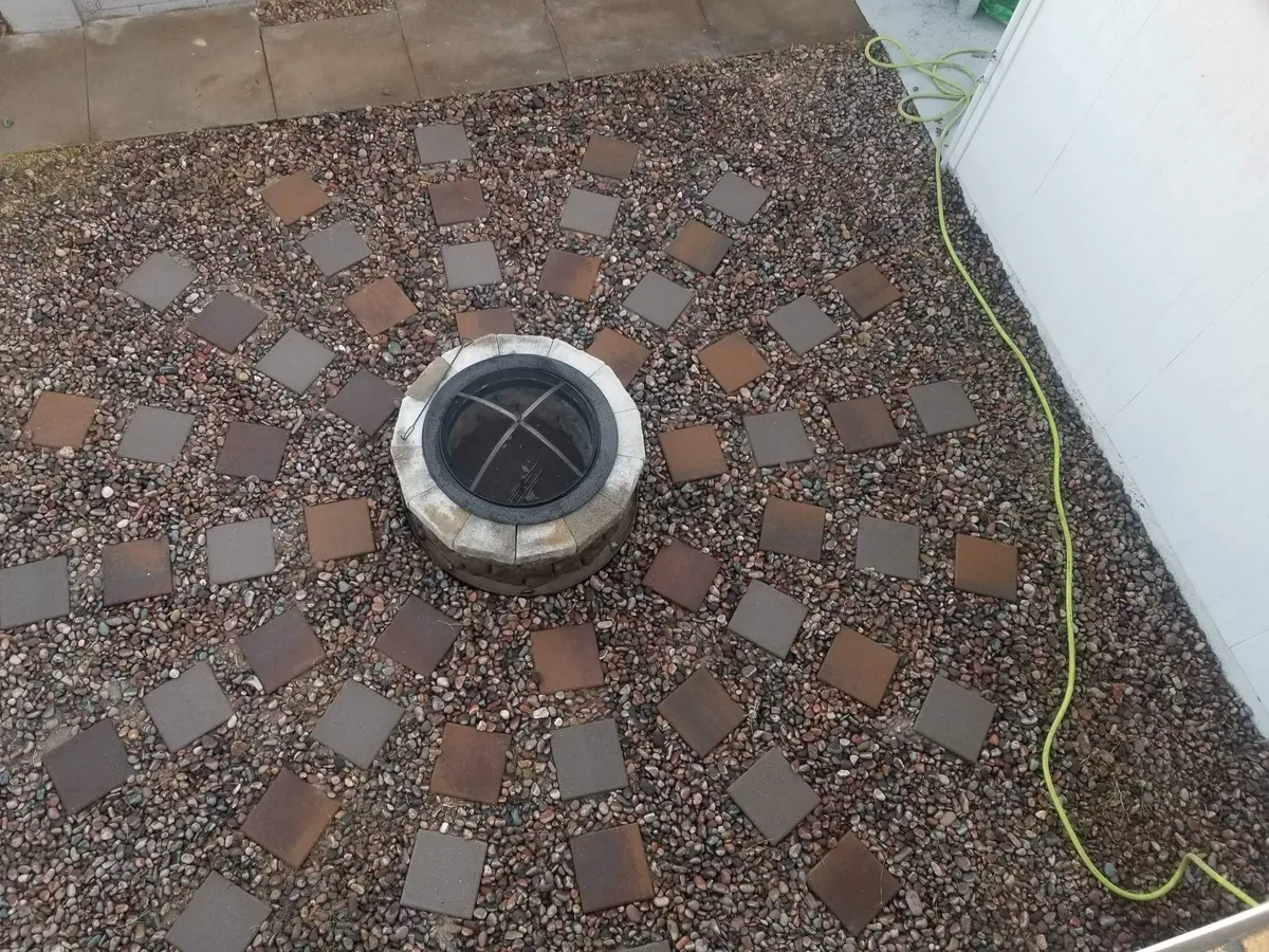 The backyard fire pit is the focal point here, encircled by a circular stone pattern on a pebbled ground. This cozy exterior space is ideal for evening gatherings, storytelling, and stargazing, aligning with the section's mention of relaxing by the fire pit after exploring nearby attractions.